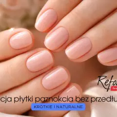 Dłonie z idealnie wykonanymi, krótkimi i **naturalnymi paznokciami** w delikatnym, różowym odcieniu. Stylizacja bez przedłużania.